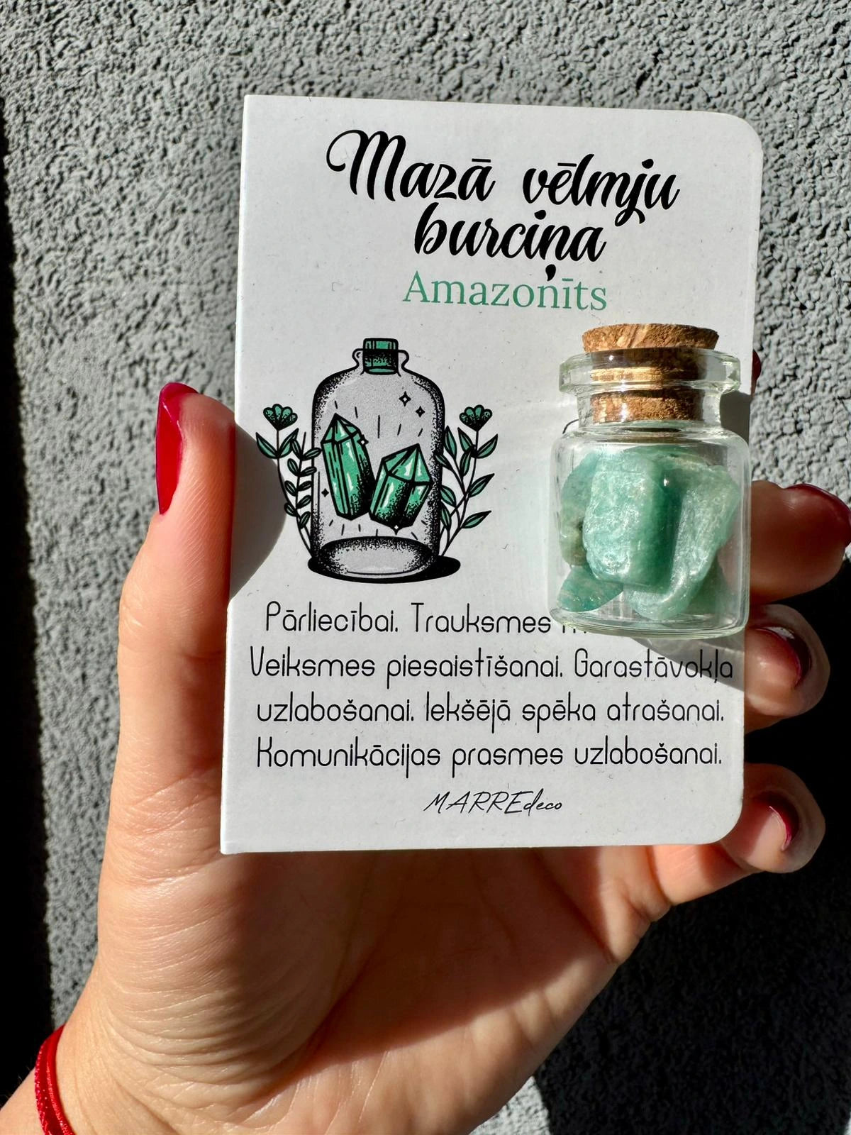 MarreDeco "Mazā vēlmju burciņa" ar amazonīta kristāliem pašpārliecībai, komunikācijas prasmēm un iekšējam spēkam, turēta rokā.