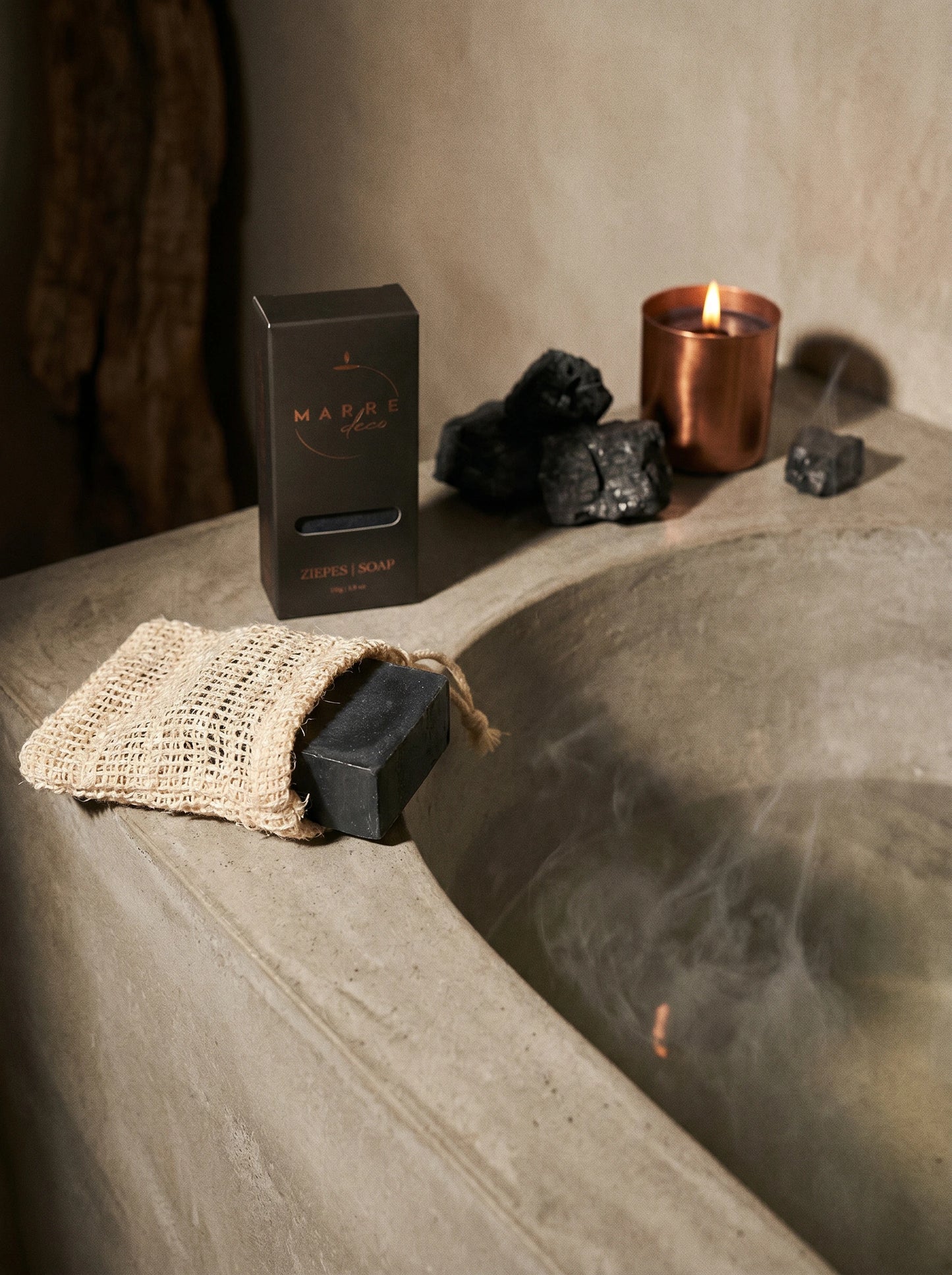 Attīrošās melnās pirts ziepes un dabīgs sizāla maisiņš pīlingam — MarreDeco vīriešu vai pirts sērijas rituāls mājīgā, dūmakainā SPA gaisotnē.