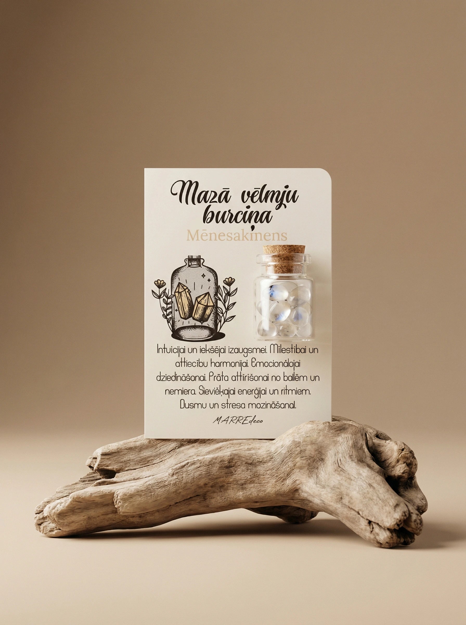 Mēnessakmens kristālu burciņa uz kartītes ar aprakstu par emocionālo dziedināšanu un stresa mazināšanu – MarreDeco ezotēriskā dāvana.