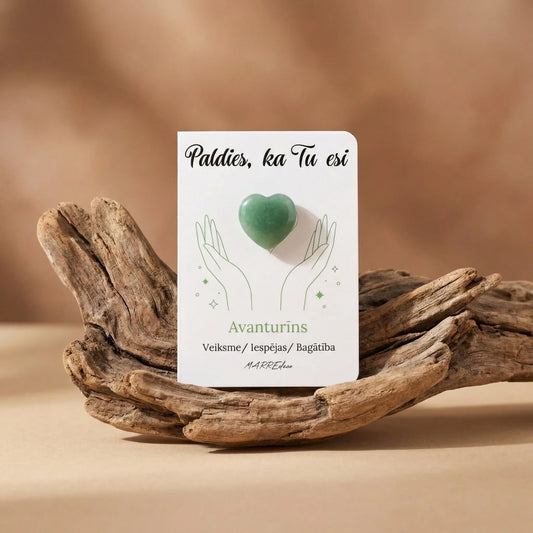 Rožu kvarca sirds formas akmens uz baltas pateicības kartītes ar tekstu "Paldies, ka Tu esi". Komplektā balts organzas maisiņš un neapstrādāti kristāli maigos, siltos toņos, marredeco